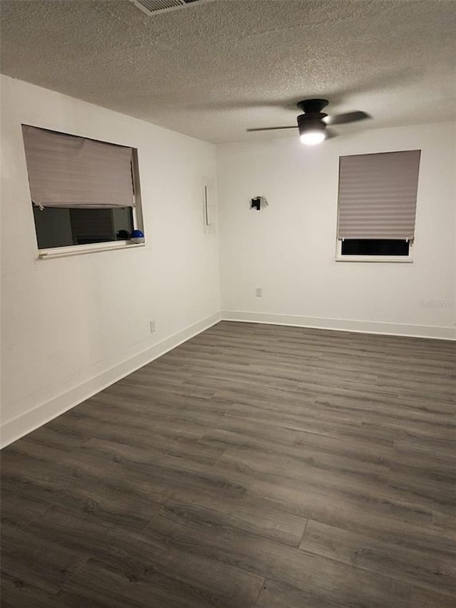 unfurnished room with a textured ceiling, ceiling fan, and dark wood-type flooring