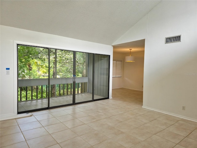 unfurnished room featuring a textured ceiling, light tile patterned floors, and high vaulted ceiling