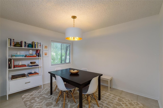 dining room with a textured ceiling and light tile patterned floors