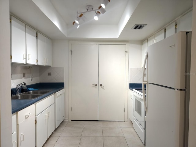 kitchen with light tile patterned flooring, tasteful backsplash, white cabinets, white appliances, and sink