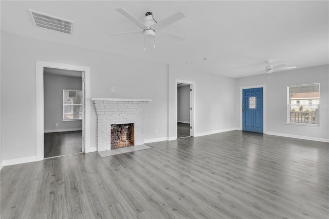 unfurnished living room featuring wood-type flooring, a fireplace, and ceiling fan