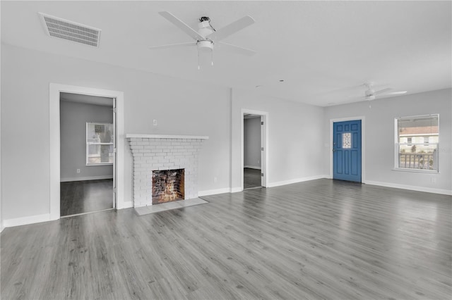 295 S Oak Ave, Bartow, FL 33830 - unfurnished living room with ceiling fan, plenty of natural light, wood finished floors, and a brick fireplace