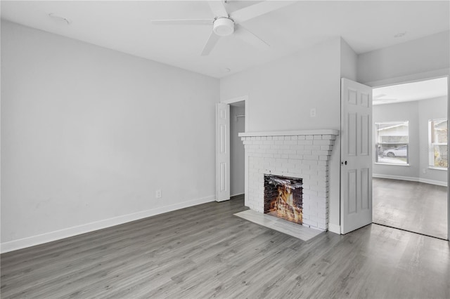 295 S Oak Ave, Bartow, FL 33830 - unfurnished living room with wood finished floors, a brick fireplace, ceiling fan, and baseboards