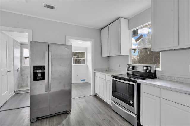 kitchen with light hardwood / wood-style flooring, white cabinetry, and stainless steel appliances