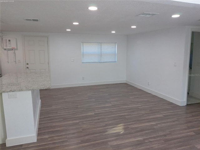 empty room featuring a textured ceiling and dark hardwood / wood-style floors