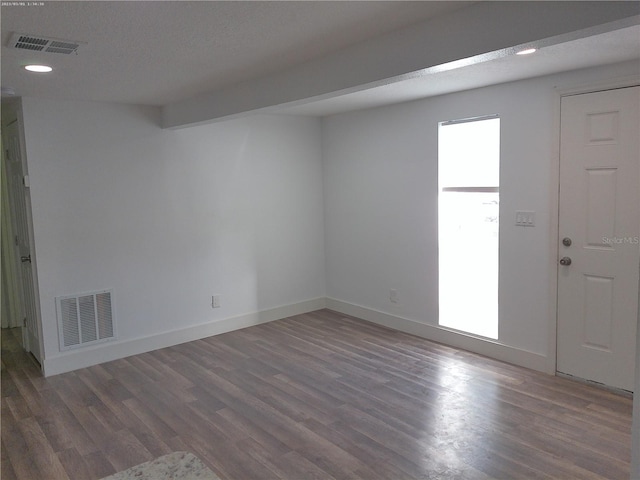 spare room with dark hardwood / wood-style floors and a textured ceiling