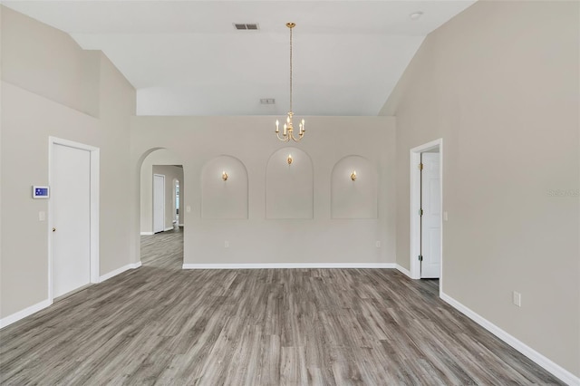 spare room featuring hardwood / wood-style floors and high vaulted ceiling