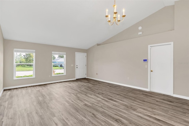 unfurnished living room featuring a chandelier, hardwood / wood-style flooring, and high vaulted ceiling