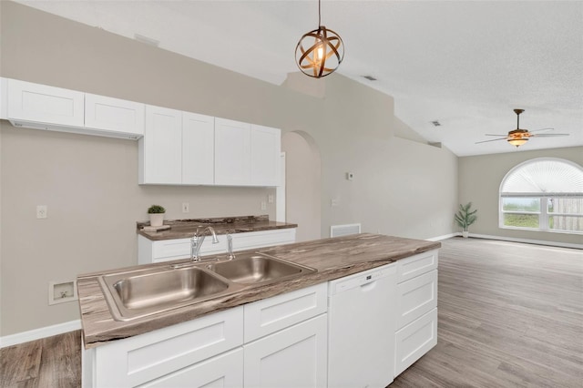 kitchen featuring white cabinets, white dishwasher, vaulted ceiling, and sink