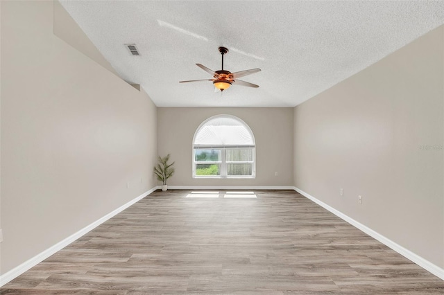 unfurnished room featuring ceiling fan, light hardwood / wood-style flooring, and a textured ceiling