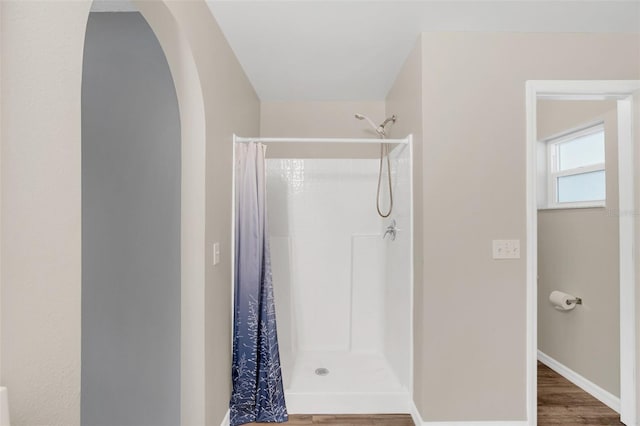 bathroom with a shower with shower curtain and hardwood / wood-style flooring