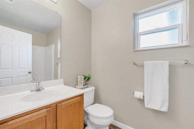 bathroom featuring a shower, vanity, and toilet