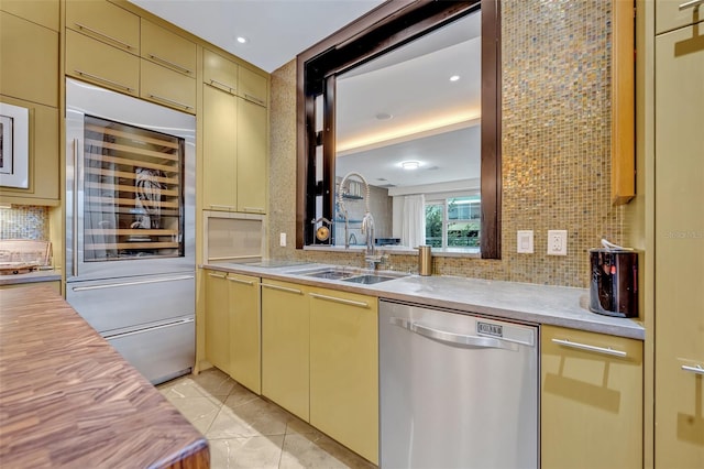 kitchen with tasteful backsplash, sink, stainless steel dishwasher, and beverage cooler