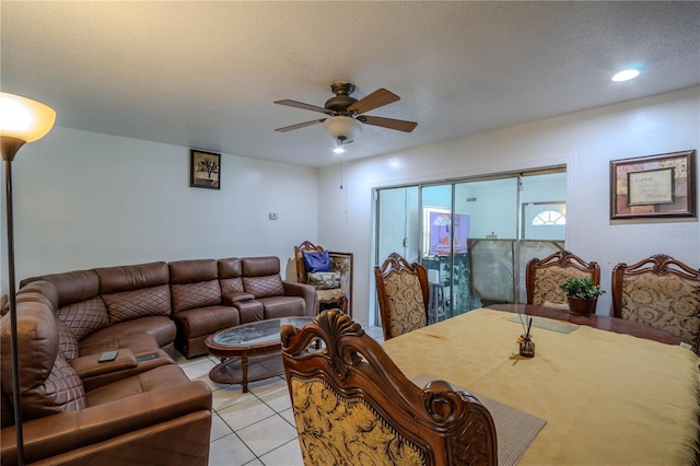 living room with a textured ceiling, light tile patterned floors, and ceiling fan