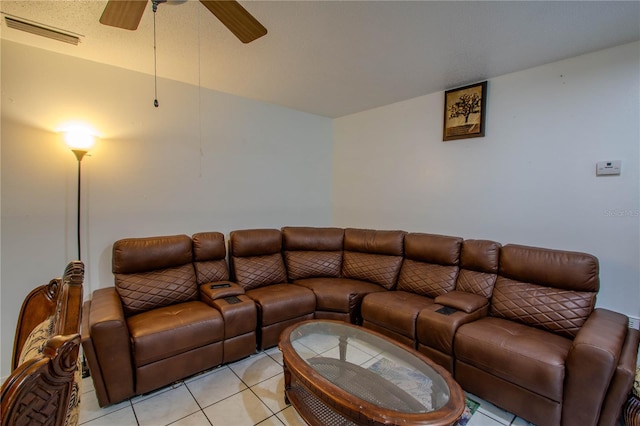 living room with ceiling fan, light tile patterned flooring, and a textured ceiling