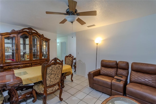 tiled living room with ceiling fan and a textured ceiling