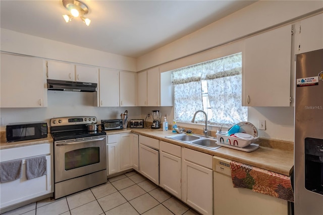 kitchen with white cabinets, light tile patterned flooring, appliances with stainless steel finishes, and sink