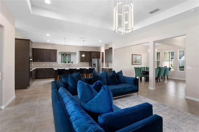 living room with light tile patterned flooring and a raised ceiling