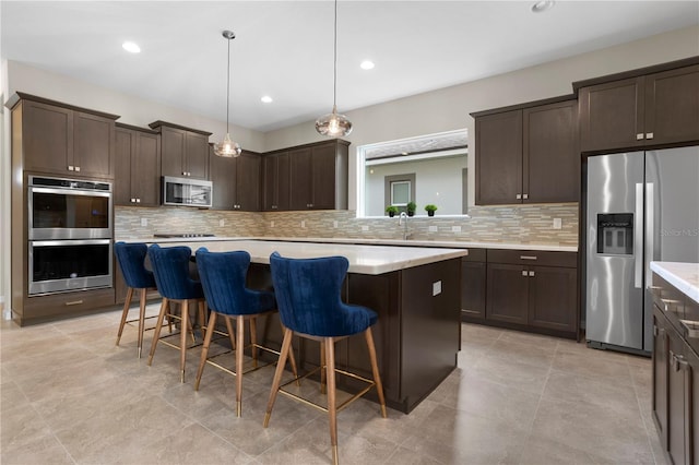 kitchen with appliances with stainless steel finishes, decorative backsplash, and a center island