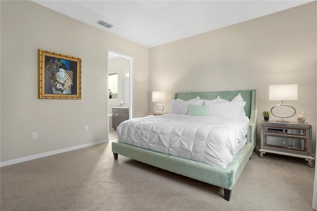 bedroom with carpet floors and connected bathroom