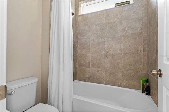 bathroom featuring toilet and shower / tub combo with curtain