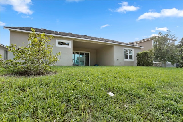 rear view of house featuring a lawn