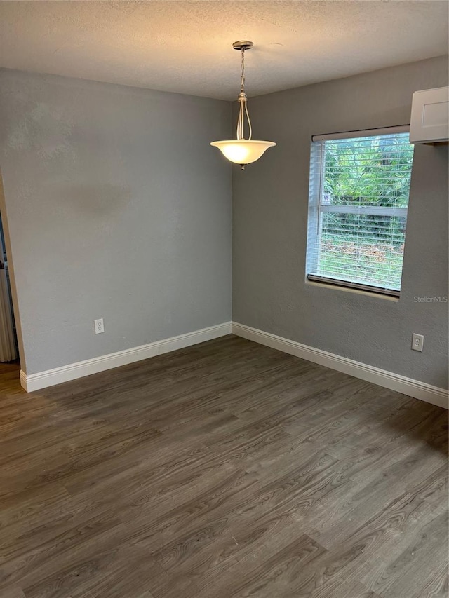 spare room featuring a textured ceiling and dark wood-type flooring