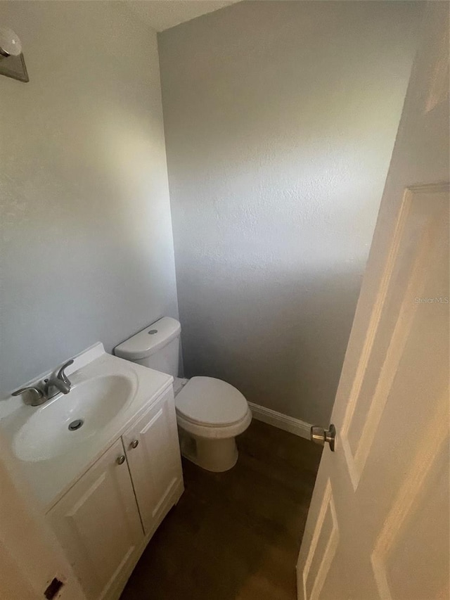 bathroom featuring hardwood / wood-style floors, vanity, and toilet