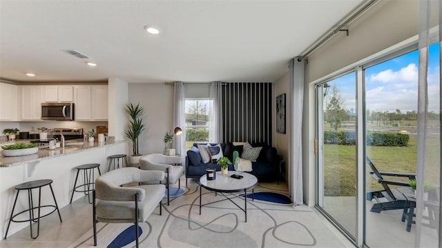 interior space with sink, light tile patterned floors, and a wealth of natural light