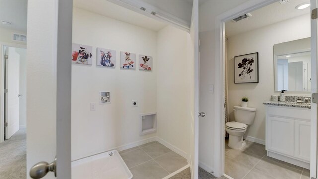 clothes washing area featuring hookup for a washing machine, light tile patterned floors, and electric dryer hookup