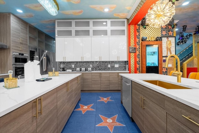 1021 Fantasy Dr, Davenport, FL 33896 - kitchen with modern cabinets, white cabinets, appliances with stainless steel finishes, backsplash, and a chandelier