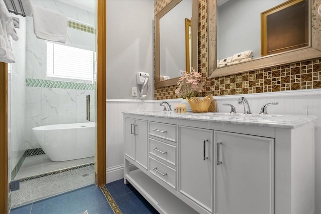 1021 Fantasy Dr, Davenport, FL 33896 - bathroom featuring double vanity, a soaking tub, a wainscoted wall, and tile patterned flooring