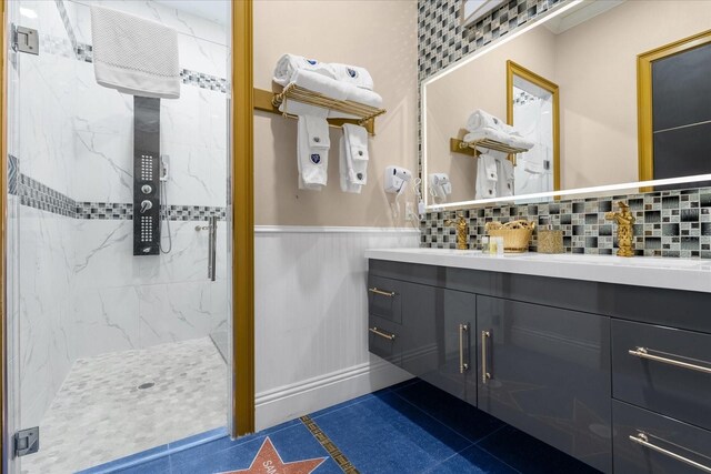 1021 Fantasy Dr, Davenport, FL 33896 - bathroom featuring a marble finish shower, vanity, and a wainscoted wall