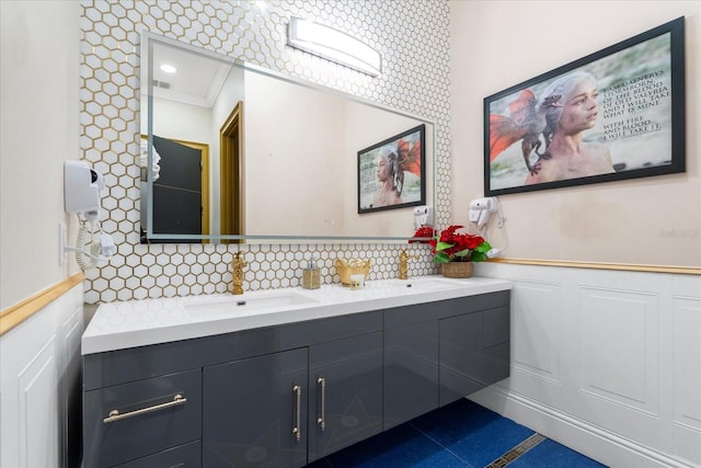 1021 Fantasy Dr, Davenport, FL 33896 - full bathroom featuring double vanity, a wainscoted wall, and tasteful backsplash