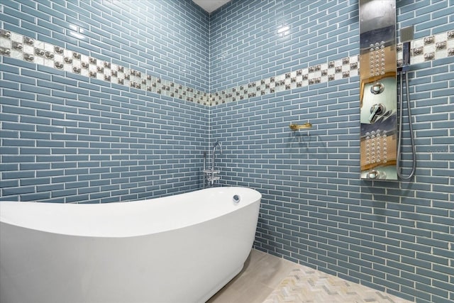 1021 Fantasy Dr, Davenport, FL 33896 - bathroom featuring tile walls, a freestanding bath, and wood finished floors