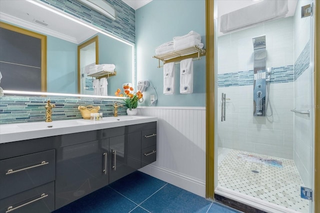 1021 Fantasy Dr, Davenport, FL 33896 - bathroom featuring double vanity, a stall shower, tile patterned flooring, wainscoting, and decorative backsplash