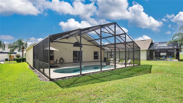 view of pool with a lawn and a lanai