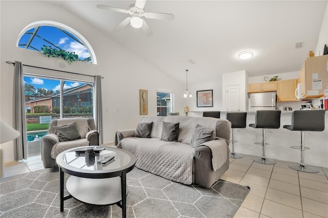 tiled living room featuring ceiling fan with notable chandelier and high vaulted ceiling