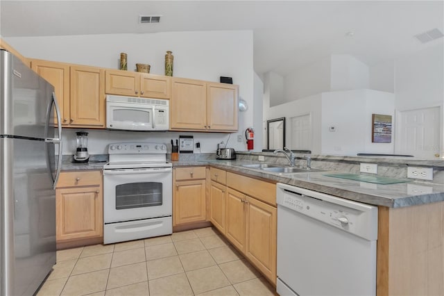 kitchen with sink, kitchen peninsula, white appliances, light brown cabinetry, and light tile patterned floors