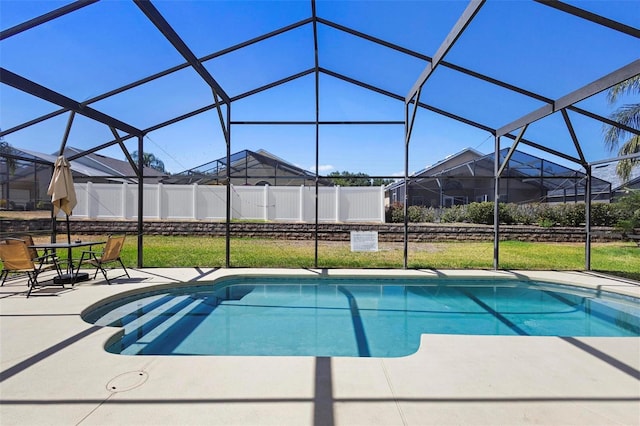 view of swimming pool featuring a lawn, a fenced in pool, a lanai, and a patio area