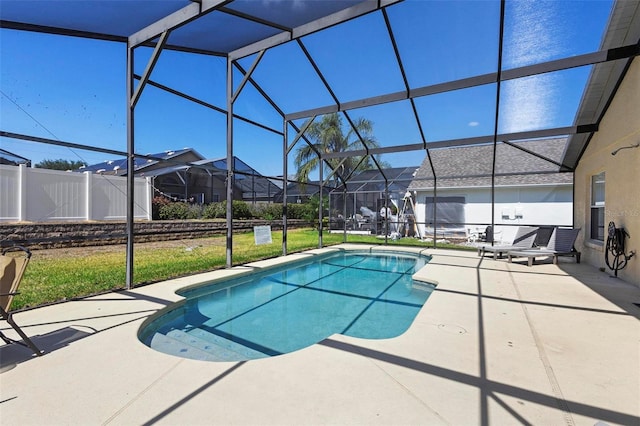 outdoor pool featuring a lawn, a patio area, and glass enclosure