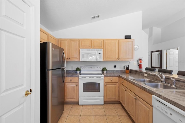 kitchen featuring visible vents, vaulted ceiling, a sink, white appliances, and light tile patterned flooring