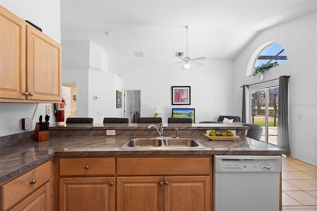 kitchen featuring visible vents, vaulted ceiling, dishwasher, a sink, and light tile patterned flooring