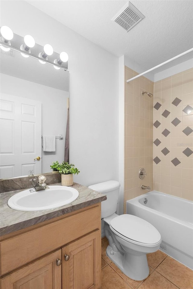 bathroom with visible vents, tile patterned flooring, vanity, toilet, and shower / tub combination