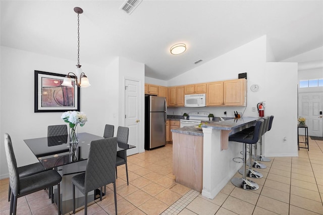 503 Balmoral Dr, Davenport, FL 33896 - kitchen featuring white appliances, a peninsula, light brown cabinets, vaulted ceiling, and a kitchen bar