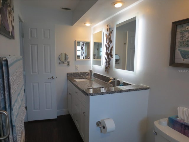 bathroom with vanity, hardwood / wood-style flooring, and toilet