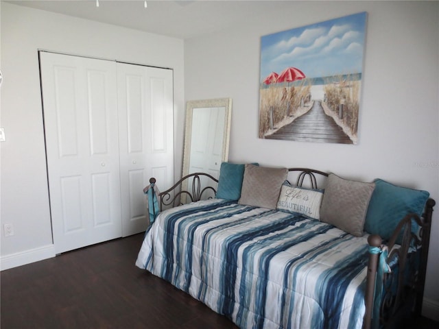 bedroom with dark wood-type flooring and a closet