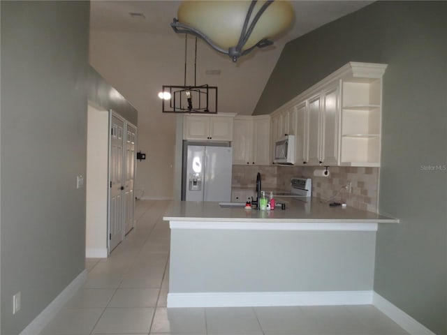 kitchen featuring kitchen peninsula, white appliances, light tile patterned floors, white cabinetry, and lofted ceiling