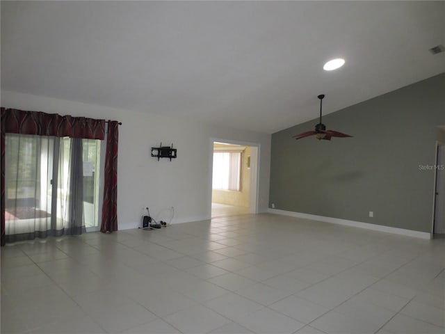 empty room with light tile patterned floors, vaulted ceiling, and ceiling fan