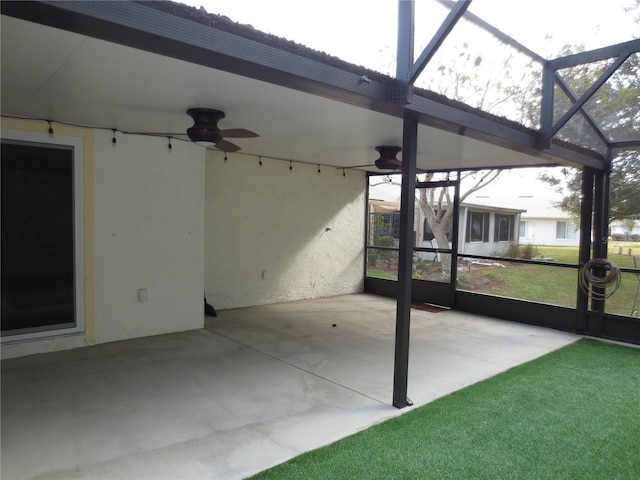 unfurnished sunroom featuring ceiling fan